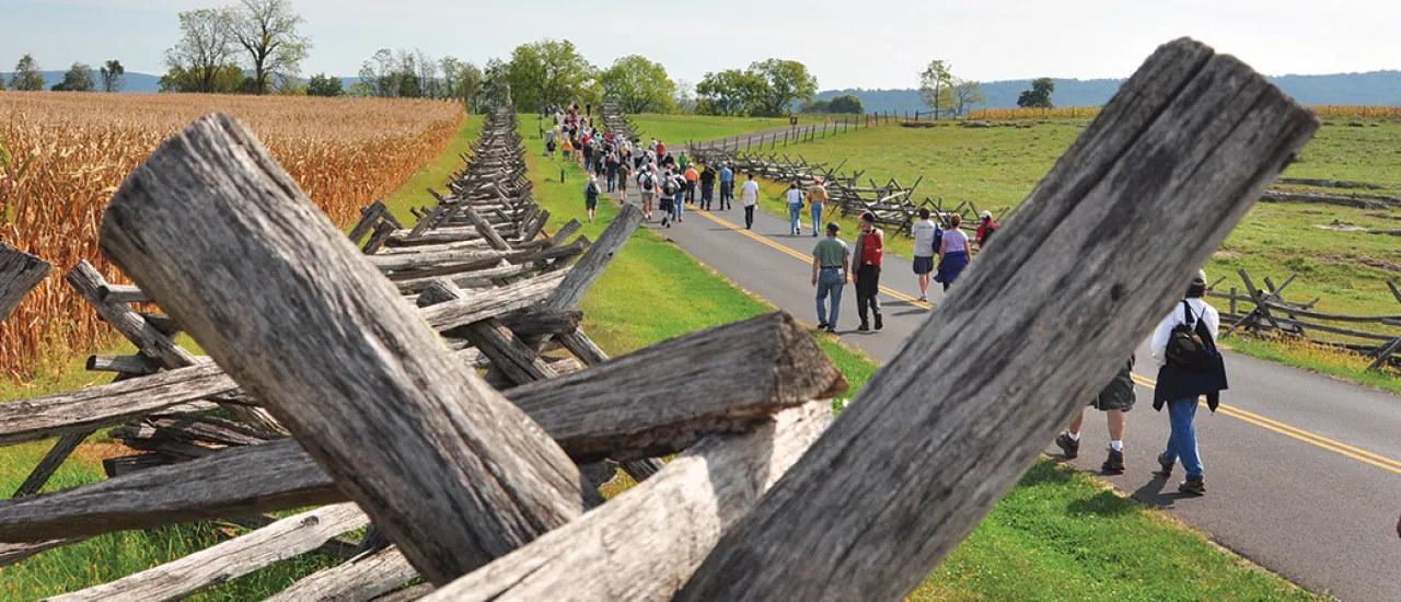 This is an image of battlefield fencing amidst people touring a battlefield. 